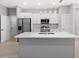 Open kitchen with stainless steel appliances, a center island, and modern pendant lighting at 24299 Kingsway Cir, Punta Gorda, FL 33983