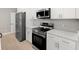 Close-up of the kitchen with stainless steel appliances and white cabinets at 24299 Kingsway Cir, Punta Gorda, FL 33983