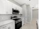 Modern kitchen with stainless steel appliances, white cabinets, and light countertops at 24299 Kingsway Cir, Punta Gorda, FL 33983