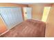 Cozy bedroom with neutral paint, large closet, carpet flooring, and view of the ensuite bathroom and kitchen at 552 Golden Raintree Pl, Brandon, FL 33510