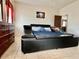 Bright bedroom featuring a large leather platform bed and tiled flooring at 724 Parker Den Dr, Ruskin, FL 33570