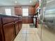 The kitchen with wood cabinets, stainless steel appliances, black countertop and tile floors provides great functionality at 724 Parker Den Dr, Ruskin, FL 33570