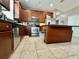Spacious kitchen with stainless appliances, wood cabinetry, black countertops, and tile flooring offers room to cook at 724 Parker Den Dr, Ruskin, FL 33570