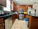 Kitchen showcasing stainless steel appliances, ample cabinetry, granite countertops, and tile flooring for cooking convenience at 724 Parker Den Dr, Ruskin, FL 33570