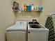 The laundry room has a washer and dryer set with storage shelving at 724 Parker Den Dr, Ruskin, FL 33570