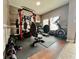 Spacious home gym with a variety of equipment including free weights, a bench press, and a stationary bike at 724 Parker Den Dr, Ruskin, FL 33570