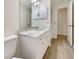 Bathroom features a single sink vanity, large mirror with vanity lighting, and wood-look flooring at 18284 Yale Ave, Port Charlotte, FL 33948