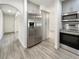 Kitchen with stainless steel refrigerator, oven, and microwave plus gray cabinets and wood-look flooring at 18284 Yale Ave, Port Charlotte, FL 33948