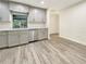 Well lit kitchen features gray cabinets, stainless steel appliances, and wood-look flooring at 18284 Yale Ave, Port Charlotte, FL 33948
