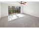 Spacious bedroom featuring a ceiling fan, balcony access, and ample natural light at 2108 Tarpon Landings Dr, Tarpon Springs, FL 34688