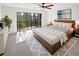 Bright bedroom features a sliding glass door to balcony and a decorative ceiling fan at 2108 Tarpon Landings Dr, Tarpon Springs, FL 34688