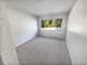 Carpeted bedroom featuring a window with bright natural light at 2108 Tarpon Landings Dr, Tarpon Springs, FL 34688