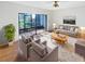 Bright living room with sliding glass doors, neutral decor, ceiling fan, and hardwood floors at 2108 Tarpon Landings Dr, Tarpon Springs, FL 34688