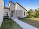 Close up of the home's entryway with a paved walkway, decorative stone accents, and well-kept landscaping at 24349 Kingsway Cir, Punta Gorda, FL 33983