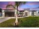 Charming home featuring well-manicured lawn, fresh landscaping and a modern black garage door at 24470 Kingsway Cir, Punta Gorda, FL 33983
