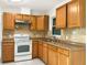 Kitchen with oak cabinets, tile backsplash and white appliances at 301 Francis Dr, Apollo Beach, FL 33572