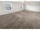 Bedroom featuring neutral carpeting, two large windows and a ceiling fan with lighting at 32100 Pop Ash Pl, San Antonio, FL 33576