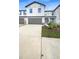 Charming two-story townhouse featuring a one-car garage, light gray facade and manicured landscaping at 32100 Pop Ash Pl, San Antonio, FL 33576