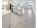 Open kitchen featuring stainless steel appliances, white cabinetry, a large center island and tile flooring at 32100 Pop Ash Pl, San Antonio, FL 33576