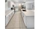 Bright open kitchen with stainless appliances, white cabinets, quartz counters and tiled floors at 32100 Pop Ash Pl, San Antonio, FL 33576
