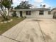 Charming single-story home with a well-maintained lawn and a long driveway at 6413 Butte Ave, New Port Richey, FL 34653