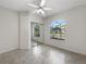 Well-lit bedroom with tile flooring, ceiling fan, arched window, and mirrored closet doors at 1110 Mcdaniel St # 1110, Sun City Center, FL 33573