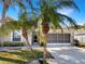 Lovely one-story home featuring a well-maintained lawn, palm trees, and a screened-in garage at 1110 Mcdaniel St # 1110, Sun City Center, FL 33573