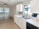 Well-lit kitchen featuring white cabinets, a stainless steel sink, and a window overlooking the backyard at 1110 Mcdaniel St # 1110, Sun City Center, FL 33573