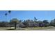 Wide street view of neighboring properties with mature palms, tiled roofs, and sidewalks at 515 Snell Isle Ne Blvd, St Petersburg, FL 33704