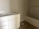 Bright bathroom featuring a white vanity with a solid surface top and a bathtub with tile surround at 7268 Deer Valley Circle, Tampa, FL 33635