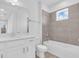 Well-lit bathroom featuring neutral-toned tile, a shower-tub combination, and a white vanity with countertop at 1067 Signet, Apollo Beach, FL 33572