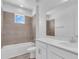 Well-lit bathroom featuring neutral-toned tile, a shower-tub combination, and a white vanity with countertop at 1067 Signet, Apollo Beach, FL 33572