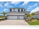 Beautiful two-story home featuring a spacious three-car garage, paver driveway, and lush landscaping at 1067 Signet, Apollo Beach, FL 33572