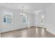 Bright living room featuring wood-look tile floors, elegant chandelier, and a freshly painted white interior at 1067 Signet, Apollo Beach, FL 33572