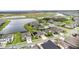 Panoramic aerial view of neighborhood homes surrounding a tranquil pond, community pool, and a playground at 5516 Madrigal Way, Apollo Beach, FL 33572