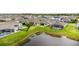 An elevated view of homes with pools overlooking a tranquil pond in a well-manicured neighborhood at 5516 Madrigal Way, Apollo Beach, FL 33572