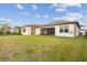 A wide view of a spacious backyard with lush green grass, fence, and a screened in lanai at 5516 Madrigal Way, Apollo Beach, FL 33572