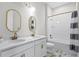 Bright bathroom featuring a double vanity with gold fixtures, a tub with shower and decorative flooring at 5516 Madrigal Way, Apollo Beach, FL 33572