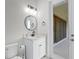 Bathroom featuring a black faucet, a round mirror, a granite countertop, and white vanity at 5516 Madrigal Way, Apollo Beach, FL 33572