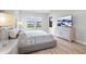 Bright bedroom with modern finishes, stylish furniture, wood flooring, and large windows for natural light at 5516 Madrigal Way, Apollo Beach, FL 33572