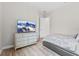 Bright bedroom featuring a comfortable bed, wood floors, and a modern dresser with television at 5516 Madrigal Way, Apollo Beach, FL 33572