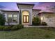 Charming home exterior with manicured lawn, arched entrance, and mature landscaping at 5516 Madrigal Way, Apollo Beach, FL 33572