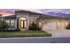 Elegant home featuring a three-car garage, arched entry, and manicured landscaping at 5516 Madrigal Way, Apollo Beach, FL 33572