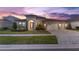 Beautifully landscaped house featuring a three-car garage and stylish exterior at 5516 Madrigal Way, Apollo Beach, FL 33572