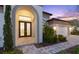 Elegant front entrance features an arched doorway and lush landscaping at 5516 Madrigal Way, Apollo Beach, FL 33572