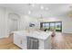 Open-concept kitchen with large island, stainless steel appliances, and adjacent living area at 5516 Madrigal Way, Apollo Beach, FL 33572
