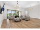 Bright living room with modern furnishings, light wood floors, and sliding glass doors at 5516 Madrigal Way, Apollo Beach, FL 33572