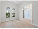 Bright living room with wood floors, two windows, and an open doorway at 5516 Madrigal Way, Apollo Beach, FL 33572