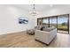 Spacious living room features comfortable seating, wood floors, and a sliding glass door to patio at 5516 Madrigal Way, Apollo Beach, FL 33572