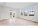 Bright living room with wood-look tile, windows, and glass doors, offering scenic views at 5516 Madrigal Way, Apollo Beach, FL 33572